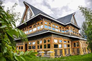 a large wooden house with a black roof at Lake Elementaita Nature Pebbles & Spar in Gilgil