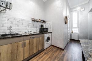 uma cozinha com um lavatório e uma máquina de lavar roupa em Райська Насолода em Lviv