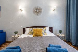 利維夫的住宿－Райська Насолода，一间卧室配有一张带蓝色和黄色枕头的大床