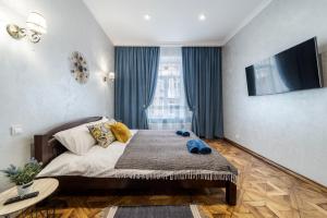1 dormitorio con 1 cama grande y TV en Райська Насолода, en Leópolis