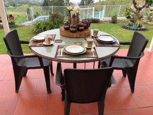 a table with four chairs and a table with plates and cups at TARAHARA salud y bienestar in Santandercito