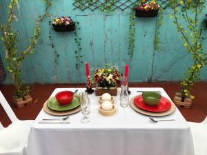 a table with a white table cloth with plates and bowls at TARAHARA salud y bienestar in Santandercito