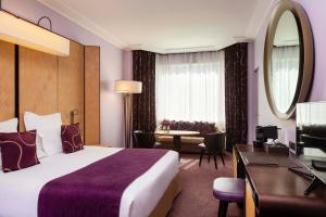 a hotel room with a large bed and a desk at Hotel Maison FL in Paris