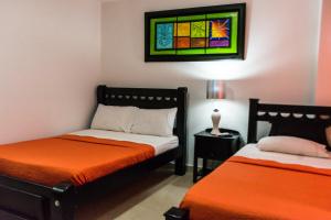 een slaapkamer met 2 bedden en een glas-in-loodraam bij Caribbean Island Hotel piso 1 in San Andrés