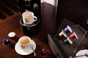 two cups of coffee on a table with a coffee maker at Hotel Maison FL in Paris