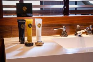 a bathroom sink with two toothbrushes and two bottles on it at Hotel Maison FL in Paris