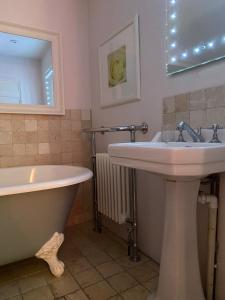 La salle de bains est pourvue d'un lavabo et d'une baignoire. dans l'établissement Oriel Cottage, Aldeburgh, à Aldeburgh