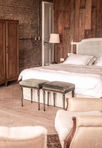 a bedroom with a bed with two benches on it at Casa Del Val - Villa María Hotel in San Bernardino