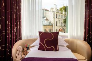two teddy bears sitting on a bed in front of a window at Hotel Maison FL in Paris +37 photos