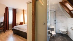 a bathroom with a bed and a glass shower at Swiss Inn & Apartments in Interlaken +17 photos