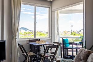 a room with a table and chairs and a window at Apartamento Ingleses Norte in Florianópolis