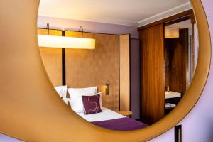 a hotel room with a bed and a mirror at Hotel Maison FL in Paris