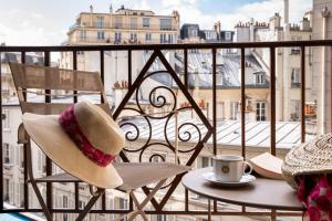 a hat and a cup of coffee on a balcony at Hotel Maison FL in Paris