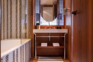 a bathroom with a tub and a sink and a mirror at Hotel Maison FL in Paris