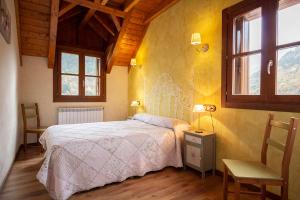 sypialnia z łóżkiem i dwoma krzesłami oraz dwoma oknami w obiekcie Apartamentos Onki Xin w mieście Isaba