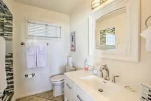 a bathroom with a sink and a toilet and a mirror at Tropical Home - 200-Yard Walk to Beach Entrance! in Oceanside