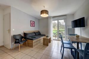 - un salon avec un canapé et une table dans l'établissement Zenitude Hôtel-Résidences L'Orée du Parc, à Divonne-les-Bains