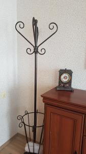 a clock on top of a wooden cabinet next to a wall at Vila Elvina in Palanga