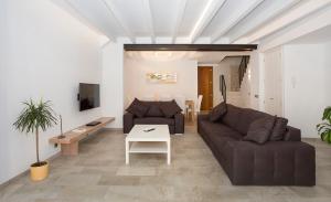 a living room with a couch and a table at ANTIGUA CASA DE PUEBLO SANT SEBASTIA in Pollença