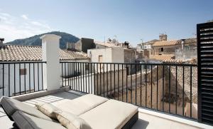 a balcony with a couch and a view of a city at ANTIGUA CASA DE PUEBLO SANT SEBASTIA in Pollença