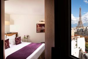 a bedroom with a bed with a view of the eiffel tower at Hotel Maison FL in Paris