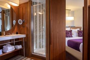 a bathroom with a bed and a shower and a sink at Hotel Maison FL in Paris