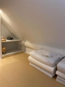 Cette chambre mansardée comprend un lit et une étagère. dans l'établissement V-WIN - Vacation STAY 07301v, à Niseko
