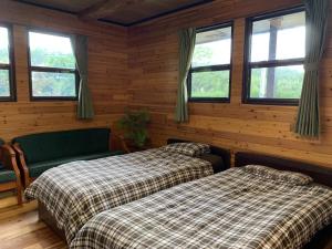 two beds in a room with wooden walls and windows at Holyday House Nagata - Vacation STAY 07980v in Nagata