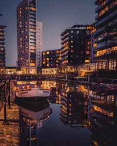 a boat in the water in front of some buildings at Deluxe City Centre Apt Balcony View& Free Parking! in Leeds