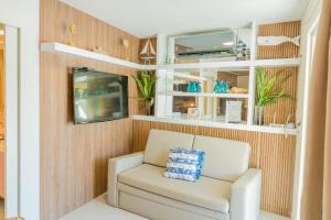 a white chair in a room with wooden walls at Solar Agua in Pipa