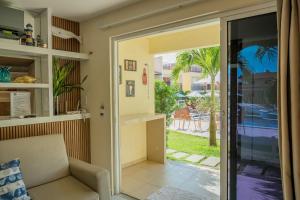 a living room with a sliding glass door to a patio at Solar Agua in Pipa