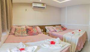 a room with two beds with flowers on them at Solar Agua in Pipa +68 photos