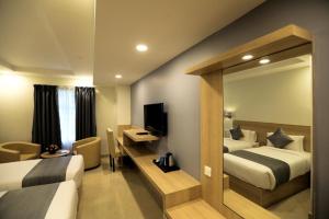 a hotel room with two beds and a television at PP Residency in Covelong +40 photos