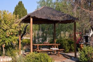 a wooden gazebo with a picnic table in a garden at Milos Traditional Windmill in Mougkelátika
