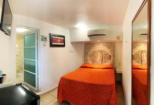 Dormitorio pequeño con cama y espejo en Bon Jesus Hotel en Costa Esmeralda