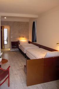 a hotel room with two beds and a table at Boutique City Hotel Gallo in St. Gallen