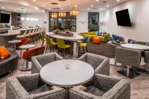 a lobby with tables and chairs and a bar at EVEN Hotel Eugene, an IHG Hotel in Eugene