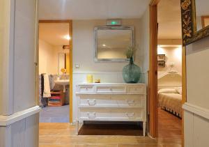 a bedroom with a dresser with a vase on it at La Seguirilla del Jerte in Casas del Castañar +60 photos
