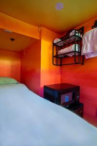 a bedroom with a bed and a tv in it at Nomads Hotel in San Clemente
