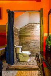 a bathroom with a toilet in a wooden wall at Nomads Hotel in San Clemente