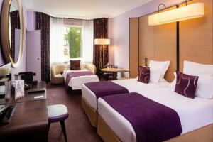a hotel room with two beds and a couch at Hotel Maison FL in Paris