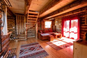 a living room with a couch in a log cabin at Zlatarske brvnare Zlatar Chalets in Nova Varoš