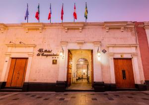 a building with a bunch of flags on top of it at Hotel Los Tambos Colonial in Arequipa