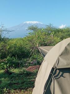 a tent with a snow covered mountain in the background at Amboseli Cultural Camping in Amboseli