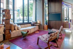 a living room with a couch and a tv at Hyatt Centric Downtown Portland in Portland