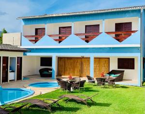 a house with a table and chairs in the yard at Recanto Dourado da Dalce in São José da Coroa Grande
