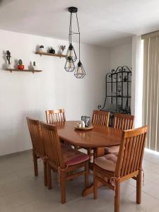ein Esszimmer mit einem Holztisch und Stühlen in der Unterkunft Casa en Oasis en Xochitepec in Chiconcuac