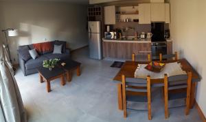 a kitchen and a living room with a table and a couch at UMAIN KAYU in San Martín de los Andes