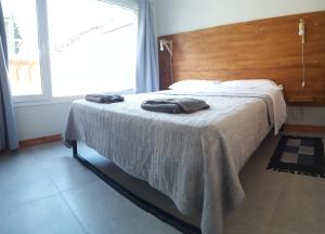 a bed with two towels on it in a bedroom at UMAIN KAYU in San Martín de los Andes