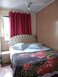 1 dormitorio con 1 cama con cortina roja en Vitória Center Plaza Praça en Nova Friburgo